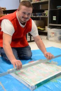 Tyler using a ruler to create an effect on a painting