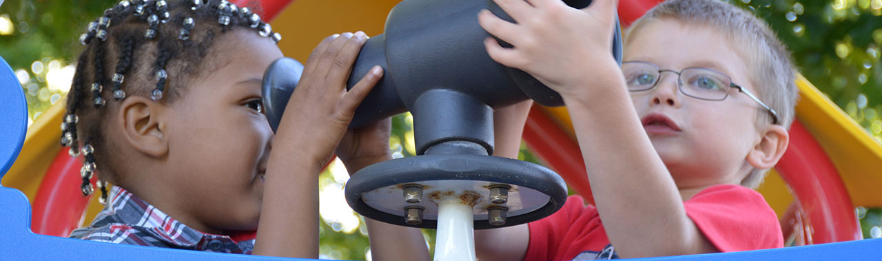 Two boys on a playground, playing.