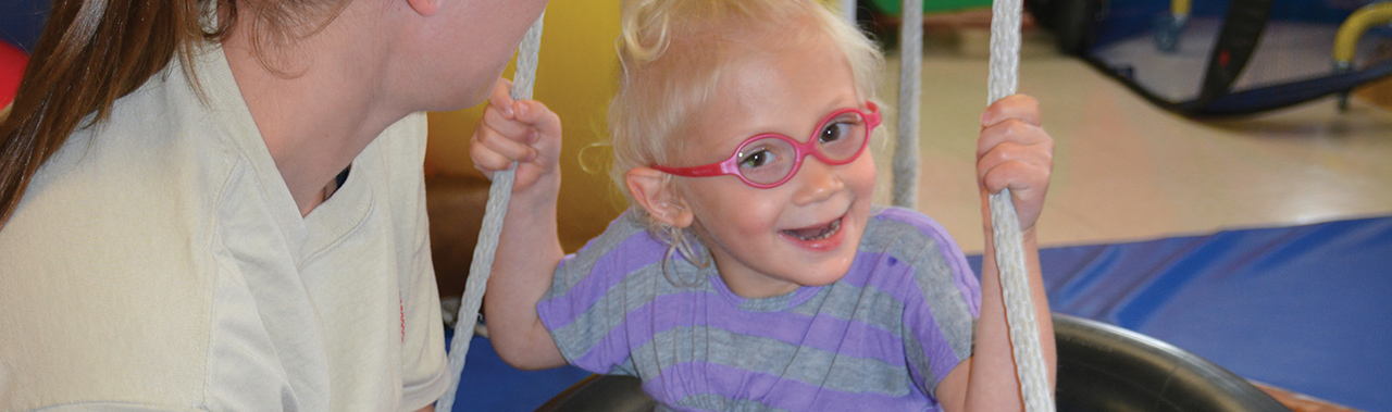 a child laughing while swinging