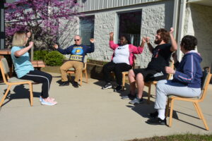 People working out in a seated position from chairs.