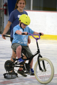 Shae Kelly with iCan Bike participant on bike