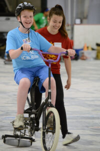 Sarah Schwomeyer with iCan Bike participant on bike