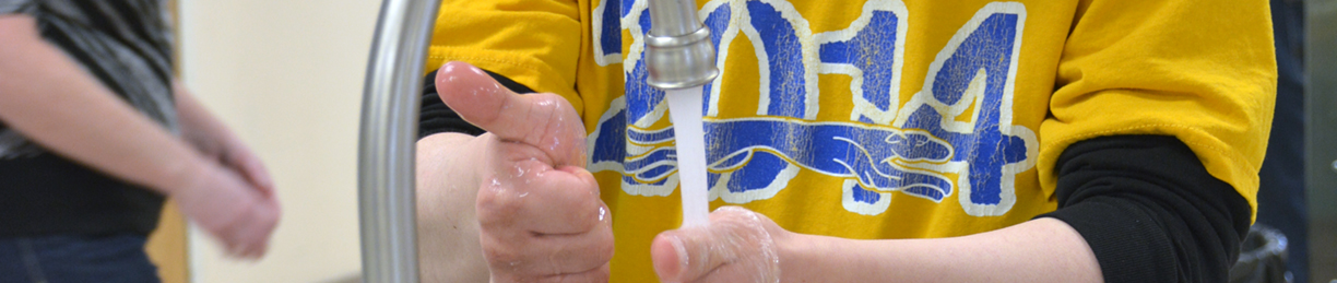 man washing hands while giving thumbs up