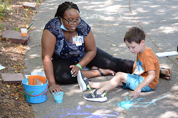 boy and adult painting with sidewalk paint