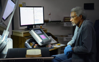 male worker scanning large volume historical book