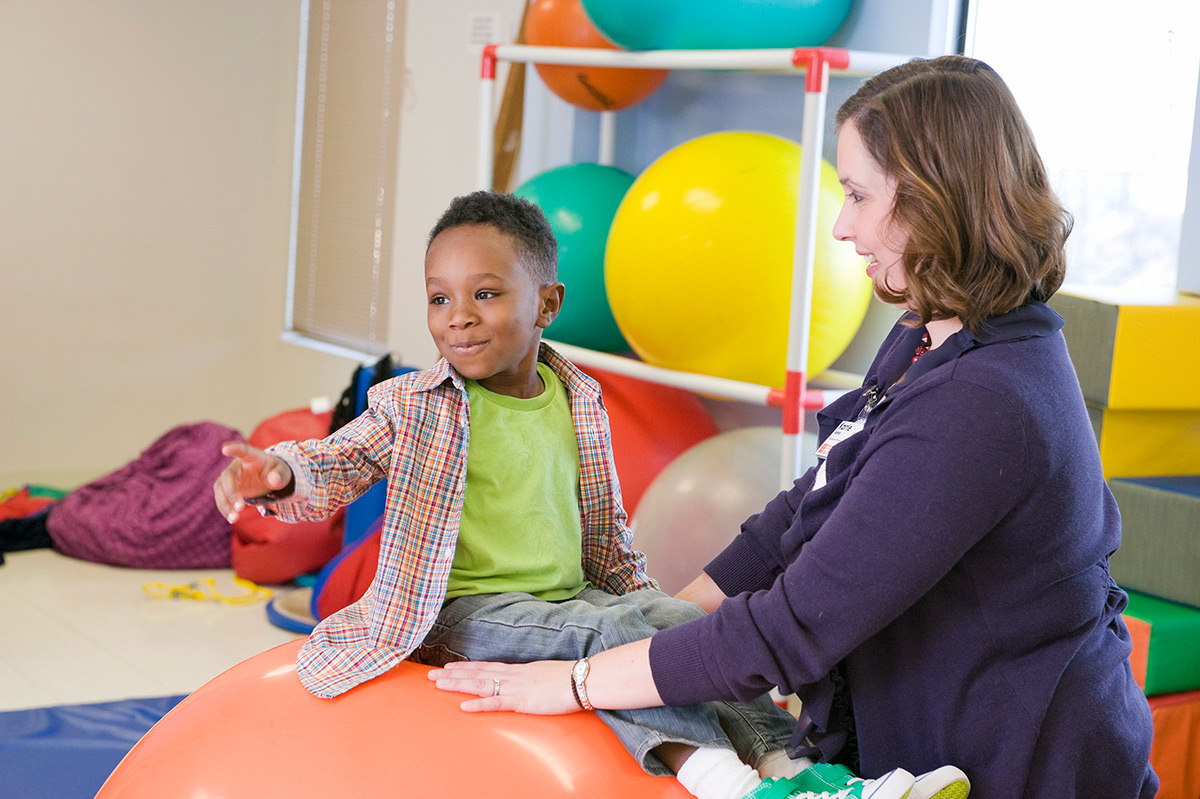 EastersealsCrossroads_1 A boy and a lady playing on a ball.