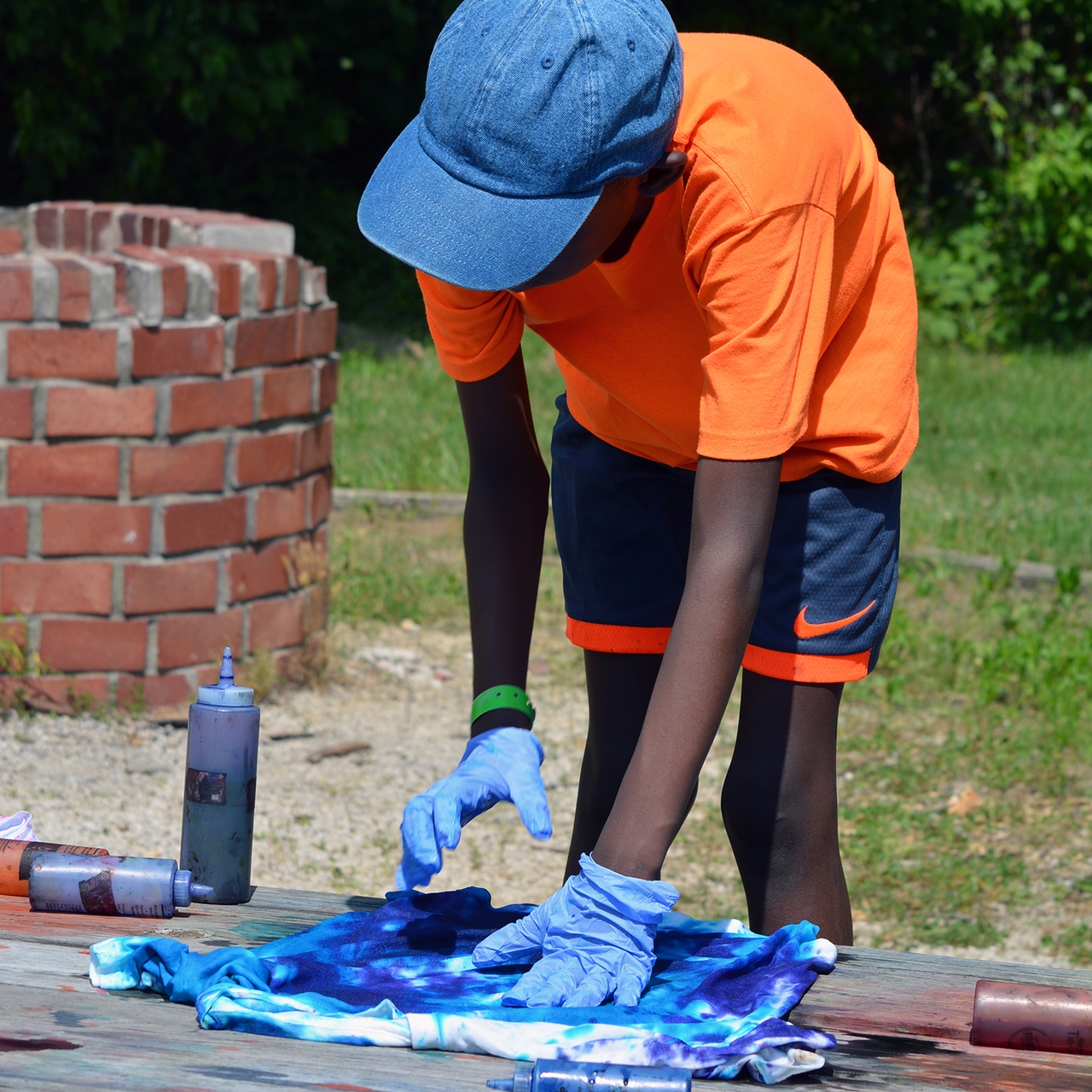 A Boy is tie-dyeing a shirt.