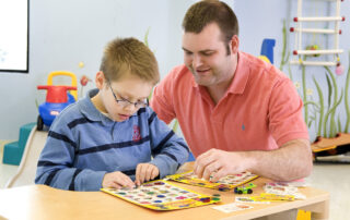 speech pathologist working with young boy