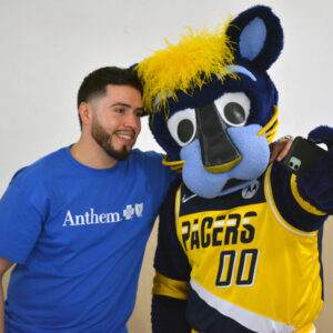 Anthem employee at Community Day event posing for photo with Boomer