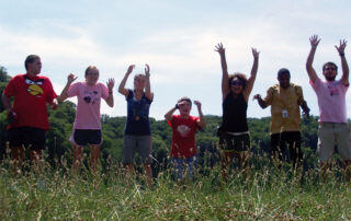 7 campers jumping in field