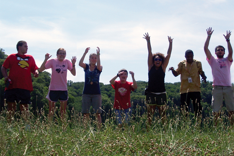 7 campers jumping in field