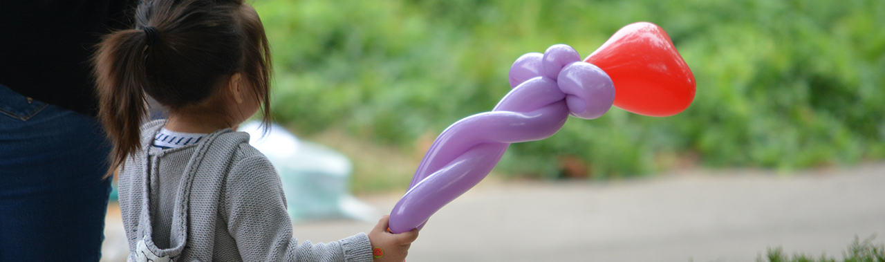 child and adult walking with balloons