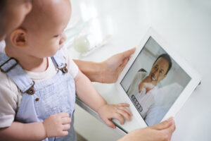 baby with mom on telehealth appointment
