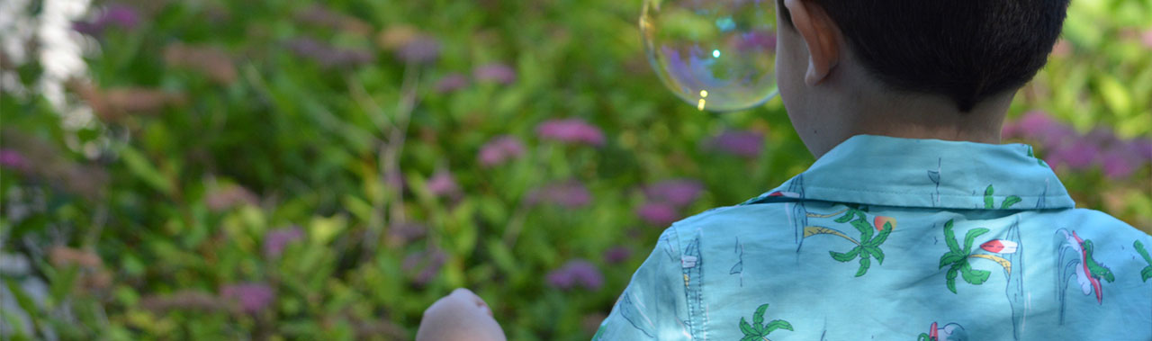 Child playing with bubbles outside.