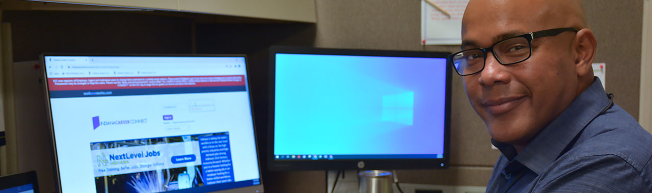 Man smiling while working on a computer.